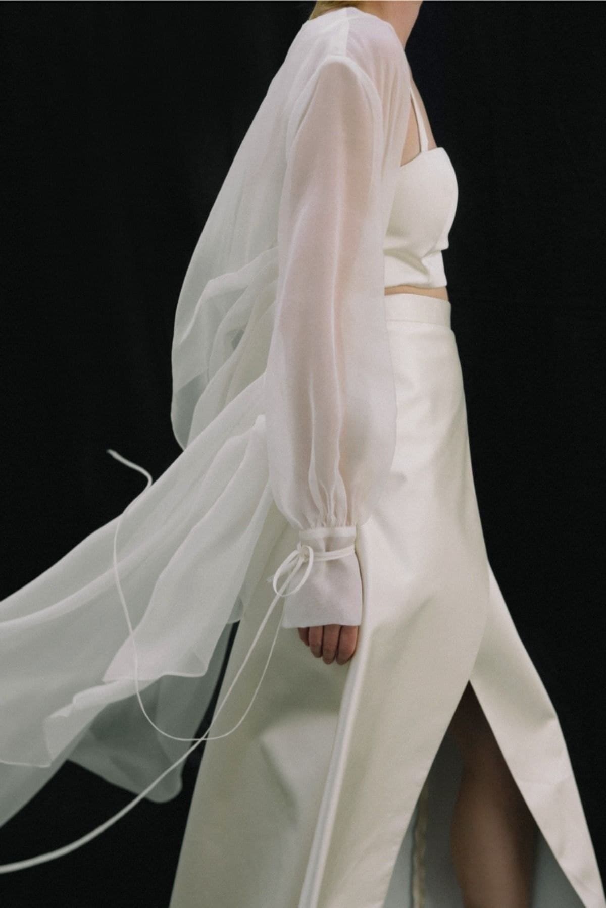 A white silk and organza look photographed in motion against black
