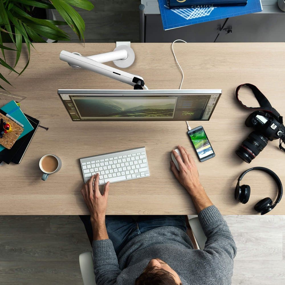 A monitor arm and workspace, photographed from above